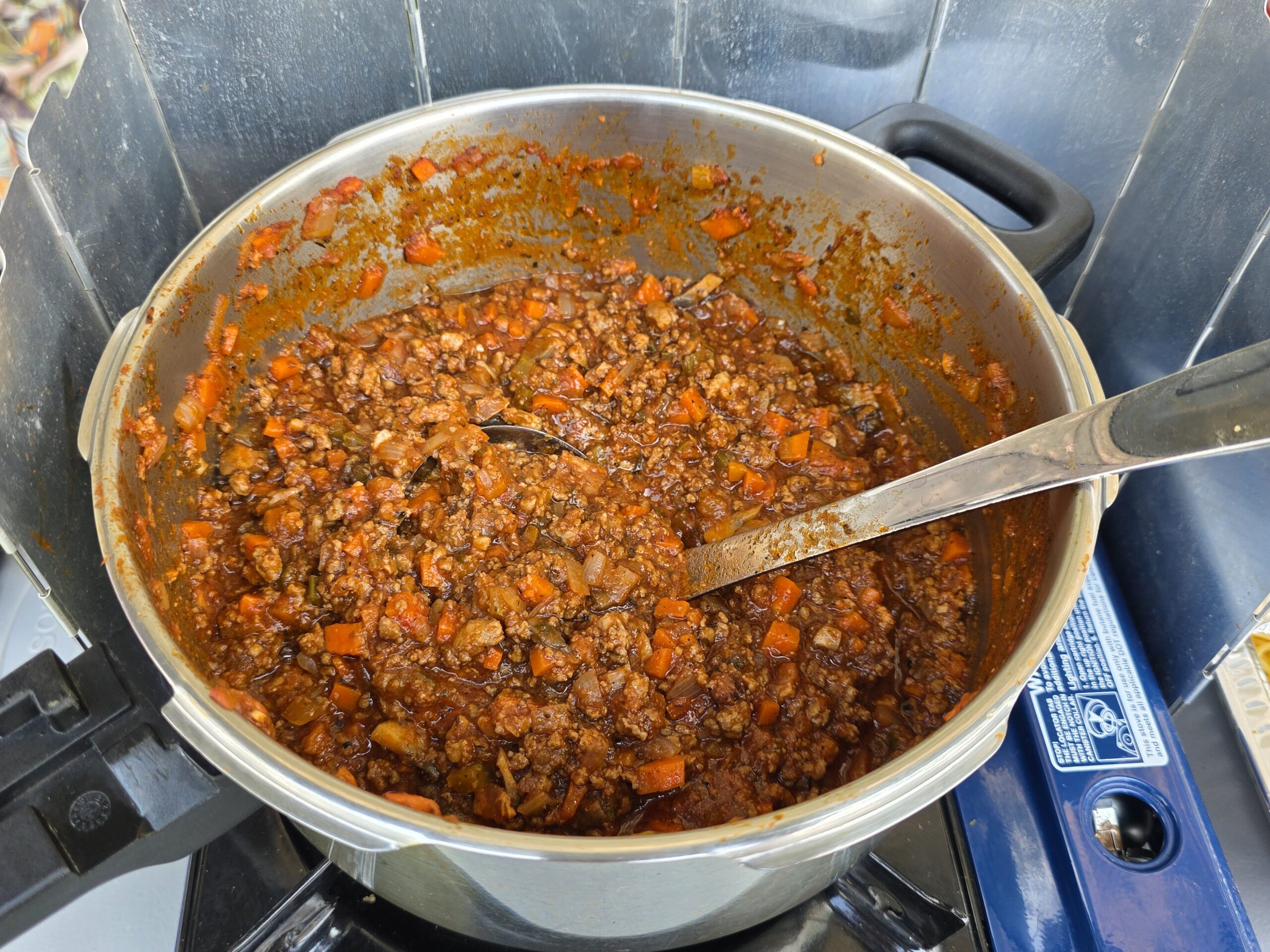 Large pot of homemade meat sauce with a full pan of spaghetti noodles for two weekend potlucks.