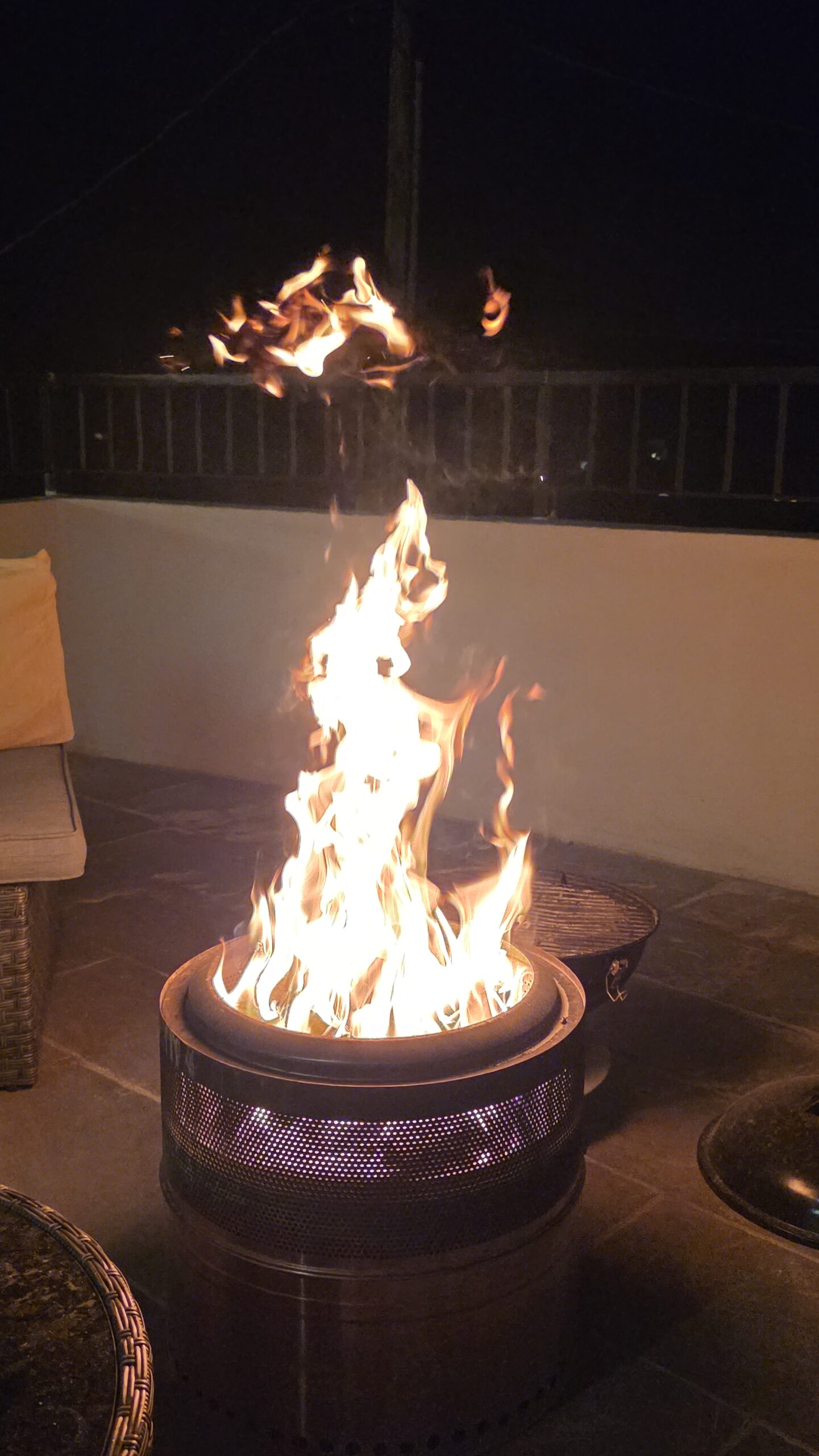 Rib-eye steak pieces cooking on skewers over a fire pit.
